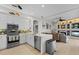 Bright kitchen with stainless steel appliances, white cabinets, quartz countertops, and an open layout to the living area at 9012 Province St, Sarasota, FL 34240