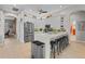Modern kitchen featuring stainless steel appliances, white cabinetry, and a quartz countertop island with bar seating at 9012 Province St, Sarasota, FL 34240