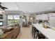 Open concept living room, dining area, and kitchen with bar stool seating and views of the outdoor pool at 9012 Province St, Sarasota, FL 34240