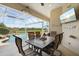 Screened patio with dining table and chairs, overlooking the pool and waterfront view at 9012 Province St, Sarasota, FL 34240