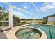 Hot tub and spa under a screen enclosure, near a bench overlooking the water at 9012 Province St, Sarasota, FL 34240