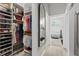 Organized walk-in closet leading to a luxurious bathroom with a soaking tub and elegant fixtures at 9012 Province St, Sarasota, FL 34240