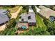 Aerial view featuring a solar-paneled roof, screened pool, complemented by verdant landscaping at 9915 Old Hyde Park Pl, Bradenton, FL 34202