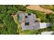 Aerial view featuring a solar-paneled roof, screened pool, complemented by verdant landscaping at 9915 Old Hyde Park Pl, Bradenton, FL 34202
