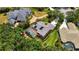 Aerial view featuring a solar-paneled roof, screened pool, complemented by verdant landscaping at 9915 Old Hyde Park Pl, Bradenton, FL 34202