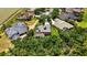 An exterior aerial view that shows the solar panel roof, the screened pool and manicured landscaping at 9915 Old Hyde Park Pl, Bradenton, FL 34202