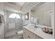 Well-lit bathroom with a glass-enclosed shower, single vanity, and a decorative mirror at 9915 Old Hyde Park Pl, Bradenton, FL 34202