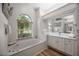 Bright bathroom with garden tub, vanity with seated make-up area, and natural light at 9915 Old Hyde Park Pl, Bradenton, FL 34202