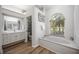 Bright bathroom featuring a soaking tub, a view to the outside, and a vanity at 9915 Old Hyde Park Pl, Bradenton, FL 34202