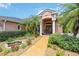 Charming front entrance with double doors, a water feature, and lush, tropical landscaping at 9915 Old Hyde Park Pl, Bradenton, FL 34202
