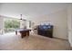 A large game room featuring a pool table, entertainment area, aquarium, and sliding glass doors to the outside at 9915 Old Hyde Park Pl, Bradenton, FL 34202