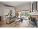 Cozy living room with a fireplace, pool views, and open access to the kitchen at 9915 Old Hyde Park Pl, Bradenton, FL 34202
