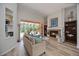 Cozy living room with a fireplace and sliding glass doors that offer a view of the screened lanai at 9915 Old Hyde Park Pl, Bradenton, FL 34202