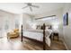 Main bedroom featuring a ceiling fan, ensuite bathroom, and double doors to the exterior at 9915 Old Hyde Park Pl, Bradenton, FL 34202