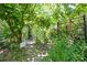 Charming backyard pathway through lush greenery with an arbor and a sign reading 'Adventure Awaits' at 9915 Old Hyde Park Pl, Bradenton, FL 34202