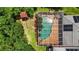 Aerial view of the screened-in pool area featuring a patio with foliage and a nearby play structure at 9915 Old Hyde Park Pl, Bradenton, FL 34202