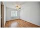 Bright bedroom featuring wood floors, ceiling fan, and large window for natural light at 1007 Southern Pine Ln, Sarasota, FL 34243