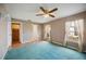 A relaxing main bedroom with two windows and ceiling fan, leading to a walk-in closet and ensuite bathroom at 1007 Southern Pine Ln, Sarasota, FL 34243
