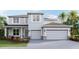 Two story home with a three car garage and professionally landscaped yard, as seen on a sunny day at 10708 Tippecanoe Pl, Parrish, FL 34219