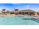 Community pool with lounge chairs and tables near the clubhouse on a sunny day at 10708 Tippecanoe Pl, Parrish, FL 34219