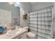 Functional bathroom with a single sink vanity, toilet, and a shower with a stylish striped curtain, creating a tidy space at 11 Lateen Sail Dr, Placida, FL 33946