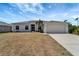 Charming single-story home featuring a two-car garage, arched windows, and tropical landscaping in the front yard at 11 Lateen Sail Dr, Placida, FL 33946