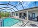 Stunning pool area with screened-in lanai, patio seating, and outdoor grilling area at 11 Lateen Sail Dr, Placida, FL 33946