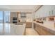 Bright open kitchen features an island, white cabinets, stainless steel appliances, and tiled backsplash at 111 S Pineapple Ave # 1210, Sarasota, FL 34236