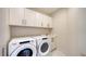 Efficient laundry room with Whirlpool washer and dryer, overhead cabinets, and clean, white finishes at 111 S Pineapple Ave # 1210, Sarasota, FL 34236