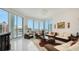 Open-concept living room featuring floor-to-ceiling windows and stylish furniture, with a view of the cityscape at 111 S Pineapple Ave # 1210, Sarasota, FL 34236