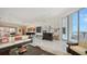 Spacious living area boasts stylish decor, a grand piano, and floor-to-ceiling windows with access to the balcony at 111 S Pineapple Ave # 1210, Sarasota, FL 34236