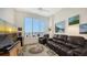 Comfortable living room with large windows offering a city view, with leather seating and a decorative rug at 111 S Pineapple Ave # 1210, Sarasota, FL 34236