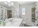 Bright bathroom with white vanity, tile shower, neutral paint, and a large mirror at 1112 65Th Nw St, Bradenton, FL 34209