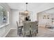 Dining room with modern chandelier and woven dining chairs with an open view to the kitchen and living room at 1112 65Th Nw St, Bradenton, FL 34209