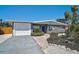 Charming single-story home with a well-manicured lawn, attached garage, and bright blue front door at 1112 65Th Nw St, Bradenton, FL 34209