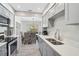 Kitchen with gray cabinets, stainless appliances, an open view to the dining room, and quartz countertops at 1112 65Th Nw St, Bradenton, FL 34209