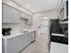 Galley kitchen featuring gray cabinets, quartz countertops, stainless appliances, and an open view to the laundry room at 1112 65Th Nw St, Bradenton, FL 34209