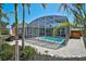 Enclosed pool area featuring a pool, lounge chairs, and views of lush tropical landscaping at 1112 65Th Nw St, Bradenton, FL 34209