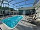 Sparkling enclosed pool with lounge chairs and outdoor seating creates a private oasis for relaxation and recreation at 1112 65Th Nw St, Bradenton, FL 34209