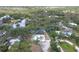 Aerial view of home surrounded by lush landscape; view of private dock, canal access, and serene backyard at 1130 Mill Creek Rd, Bradenton, FL 34212