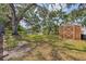 Spacious backyard features mature trees, lush lawn, and a wooden shed at 1130 Mill Creek Rd, Bradenton, FL 34212