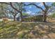 Spacious backyard features large trees, lawn, and a screened-in pool at 1130 Mill Creek Rd, Bradenton, FL 34212