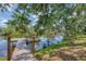 Inviting backyard features a private wooden dock on tranquil waters with mature trees and lush landscaping at 1130 Mill Creek Rd, Bradenton, FL 34212