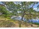 Serene backyard with water access, a private dock, and large mature tree providing shade at 1130 Mill Creek Rd, Bradenton, FL 34212