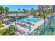 A vibrant pool area with sunbathers, bright umbrellas, and a cozy cabana, nestled among swaying palm trees at 1155 Lake House Cir # C119, Sarasota, FL 34242
