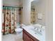 Cozy bathroom featuring a vanity with a sink, toilet, and a shower/tub with decorative curtain at 116 Navigation Cir # 106, Osprey, FL 34229