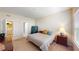 Neutral bedroom with a queen bed, side tables, closet, and a view to the laundry room and hallway at 116 Navigation Cir # 106, Osprey, FL 34229