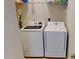 Bright laundry room with side-by-side white washer and dryer at 116 Navigation Cir # 106, Osprey, FL 34229