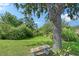 Secluded backyard area with an old-growth tree, bench, and verdant lawn at 12133 Forest Park Cir, Bradenton, FL 34211
