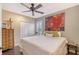 Bedroom with a ceiling fan, a bed with white bedding, a closet with sliding doors, and wood shutters at 12133 Forest Park Cir, Bradenton, FL 34211